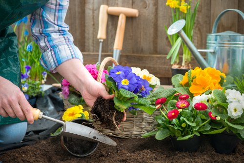 Gardening operative wearing PPE while pruning a hedge